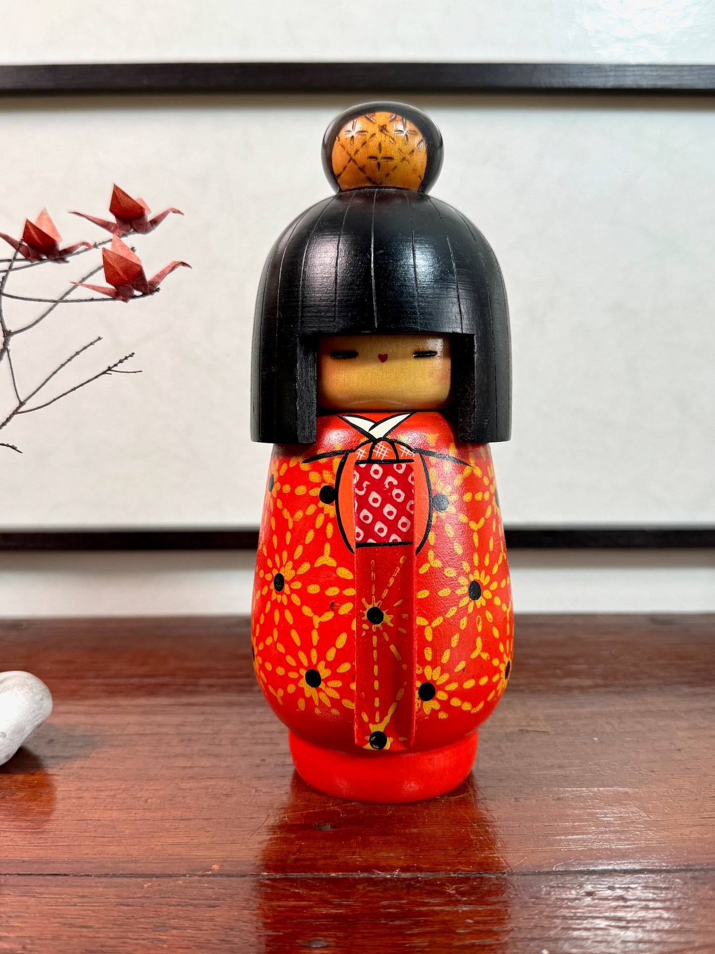 kokeshi de Kazuo tamikazawa, kimono rouge motif fleurs stylisées, cheveux noirs avec chignon pyrogravé