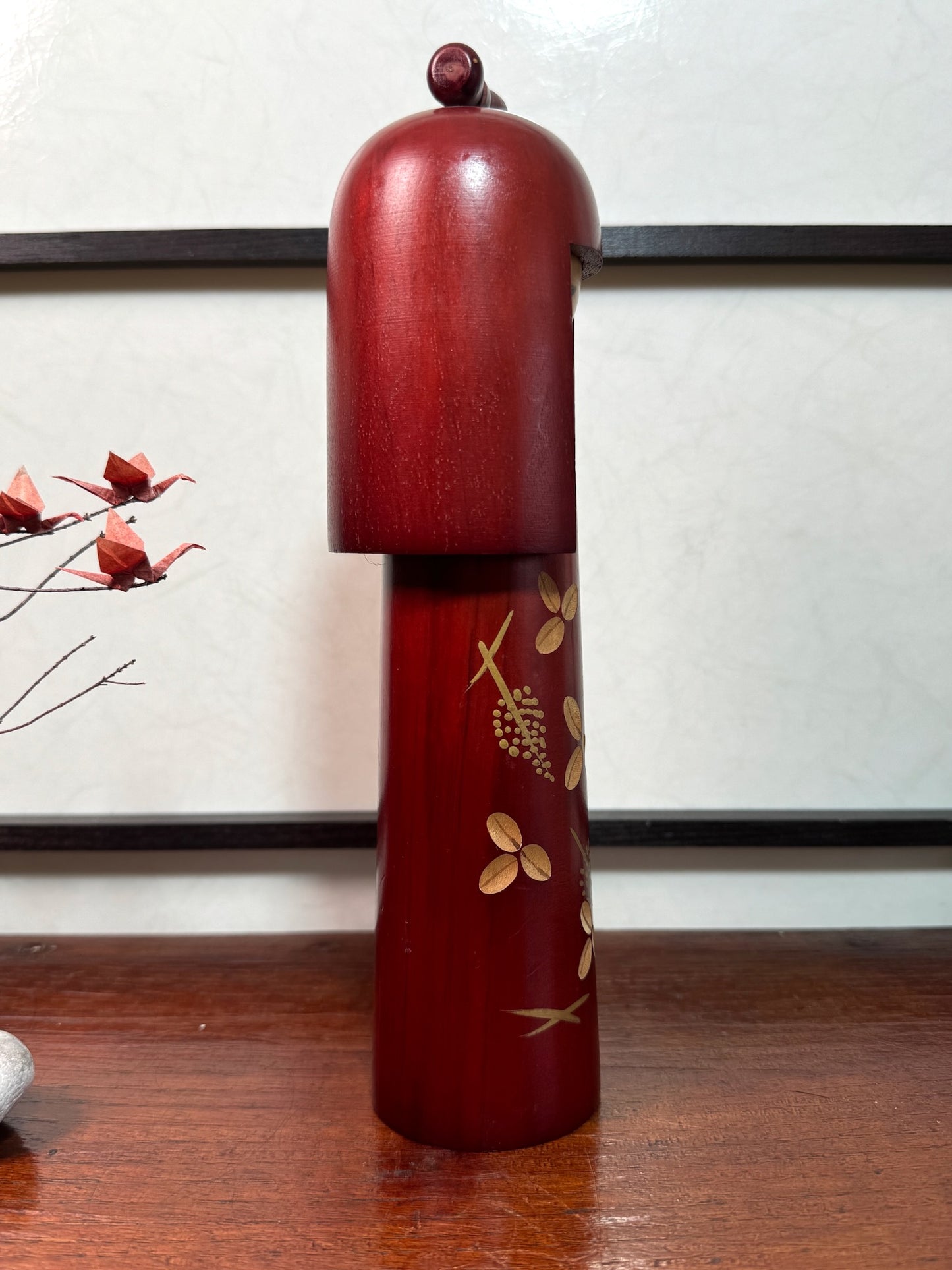 kokeshi poupée japonaise en bois de Miyashita Hajime, longue et fine, couleur acajou, fleurs gravée, long cheveux, noeud sur la tête, profil droit