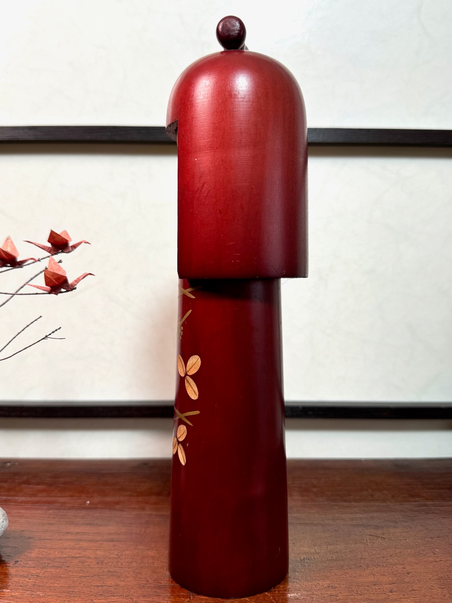 kokeshi poupée japonaise en bois de Miyashita Hajime, longue et fine, couleur acajou, fleurs gravée, long cheveux, noeud sur la tête, profil gauche