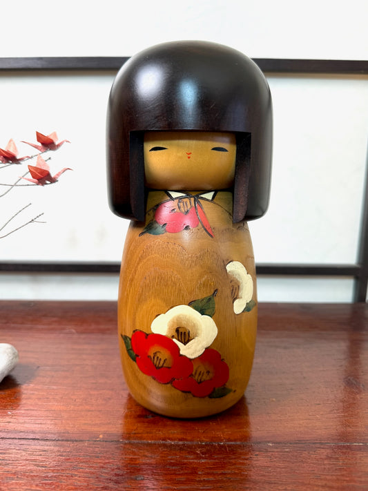 kokeshi poupée japonaise en bois de Usaburo, décor fleurs de camélia rouge et blanc sur bois blond, coiffure brune au carré, visage clair et souriant