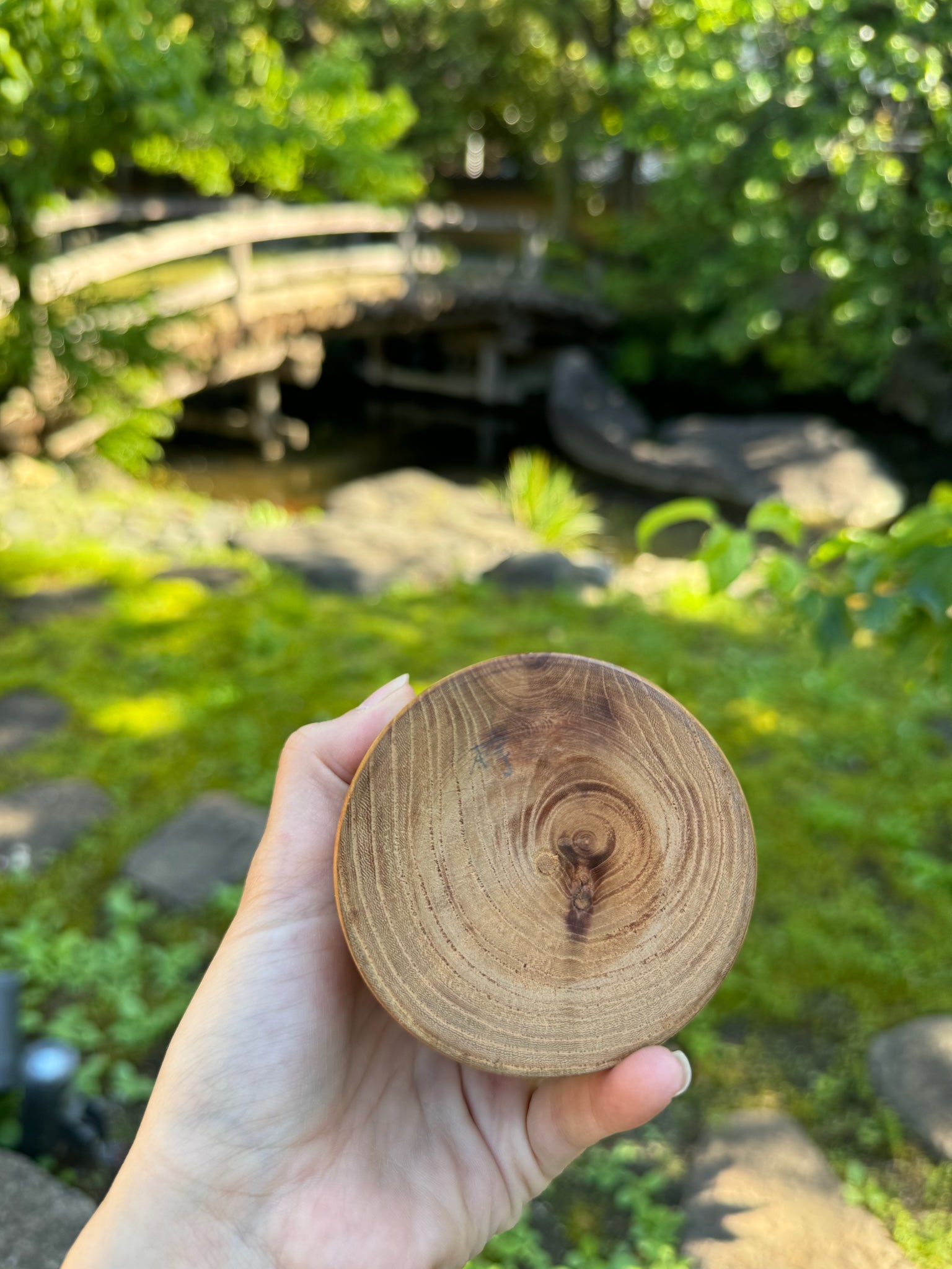 kokeshi, poupée japonaise traditionnelle en bois avec un motif de cerisier en fleurs, vu du dessous