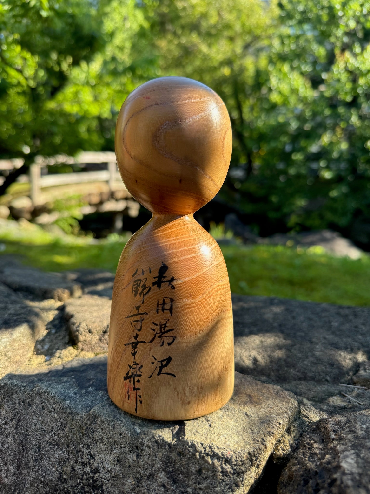 kokeshi, poupée japonaise traditionnelle en bois avec un motif de cerisier en fleurs, dos et signature de l'artisan