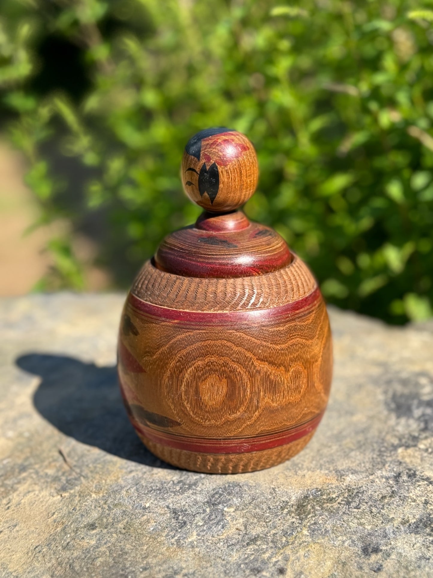 kokeshi poupée japonaise en bois enfant dans panier en bois Enju porte-bonheur, profil gauche