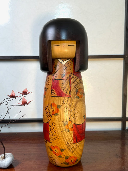 kokeshi poupée japonaise en bois blond de Usaburo, nommée Kantsubaki, motif fleurs de camélia et tissu pyrogravés, cheveux forme casque noir style gunma