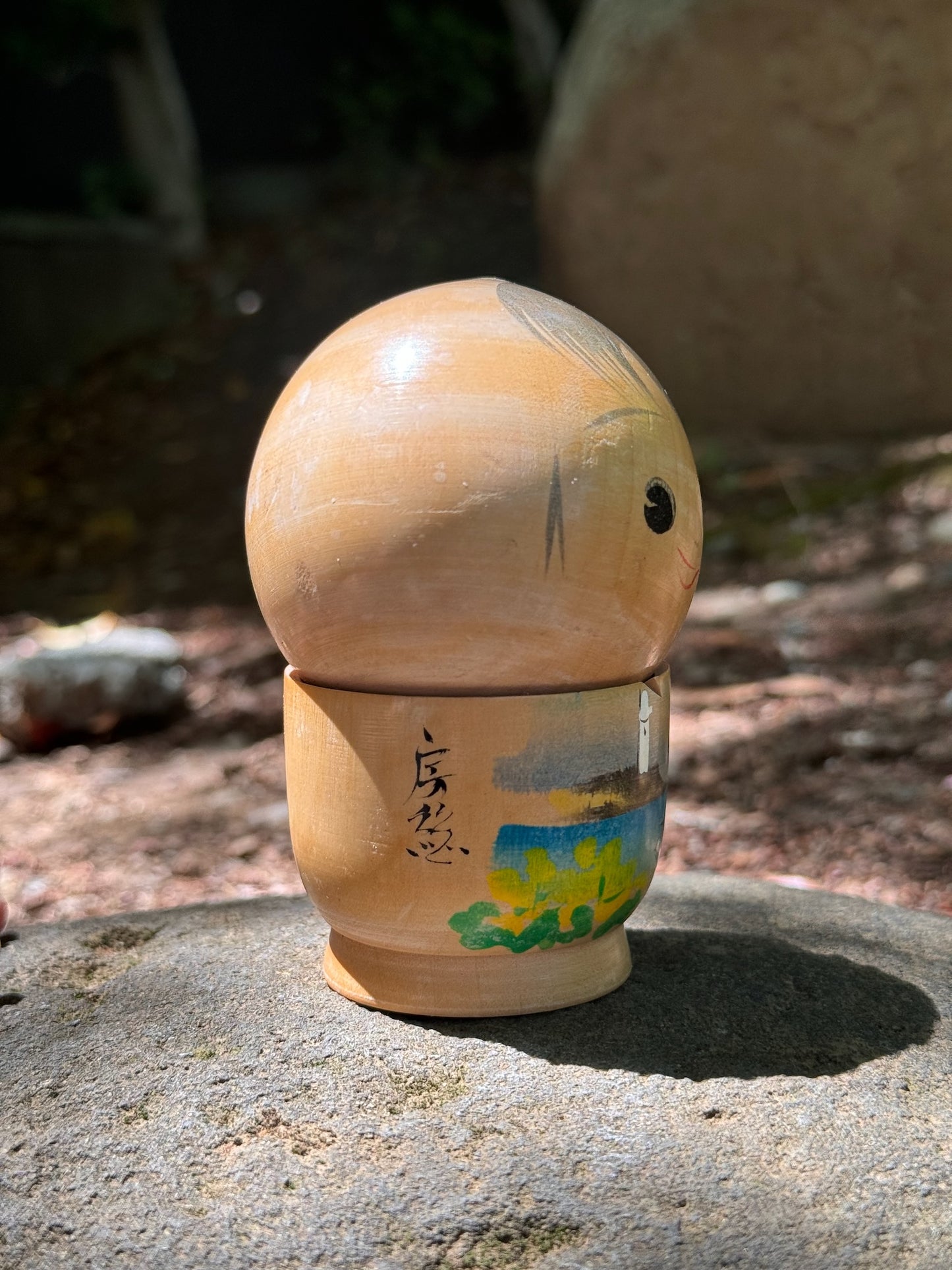 kokeshi poupée japonaise en bois souriante avec paysage bord de mer et poisson, profil droit