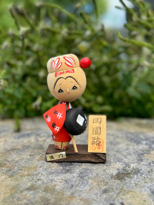 Kokeshi souvenir, poupée en bois japonaise, kimono orange et chapeau noir et blanc, pèlerinage de shikoku, épingle à cheveux rouge ronde, ruban peint et fleurs blanches sur chignon. 