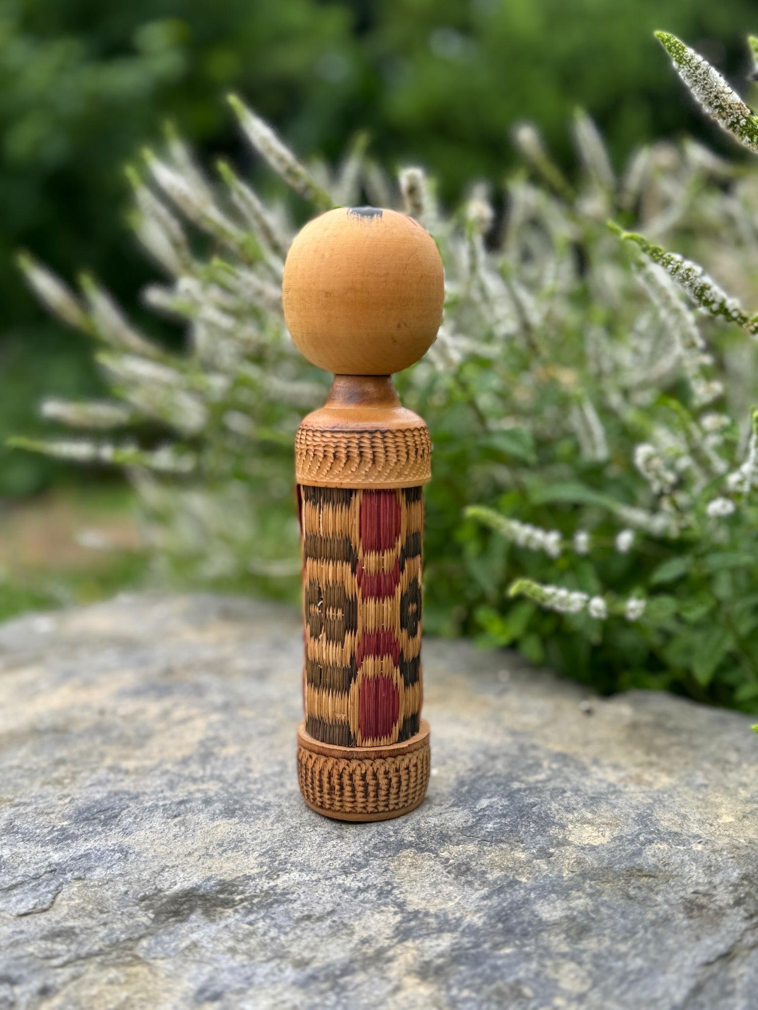 kokeshi, poupée japonaise en bois au corps en tatami à motif géométrique rouge et noir, vu de dos