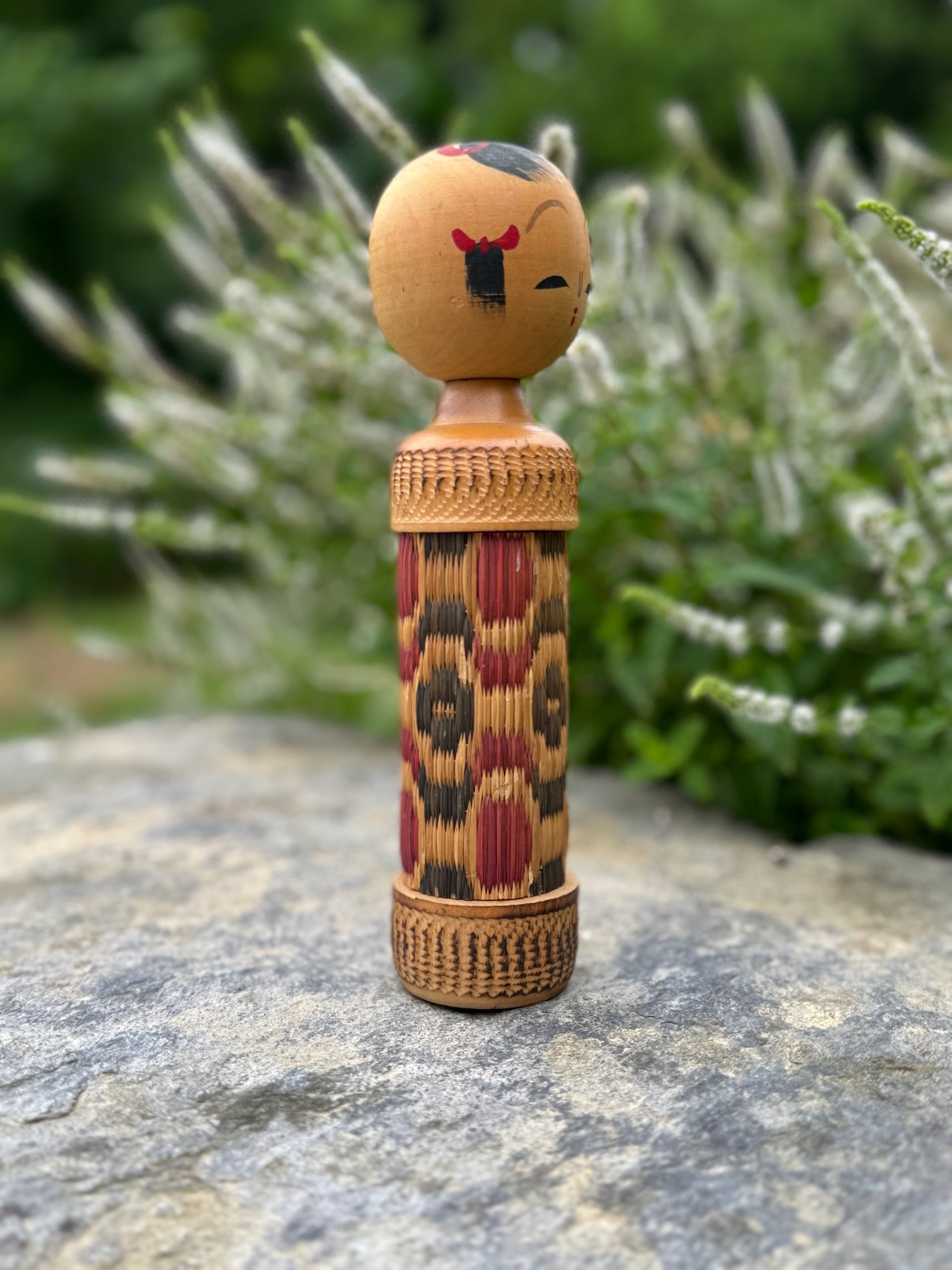 kokeshi, poupée japonaise en bois au corps en tatami à motif géométrique rouge et noir, profil droit