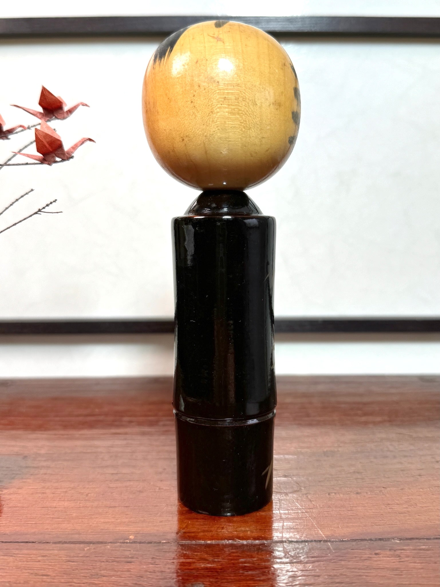 kokeshi, poupée japonaise en bois laqué noir de Takahashi Tatsuro, motif feuilles d'érable orange et bambou, vu de dos