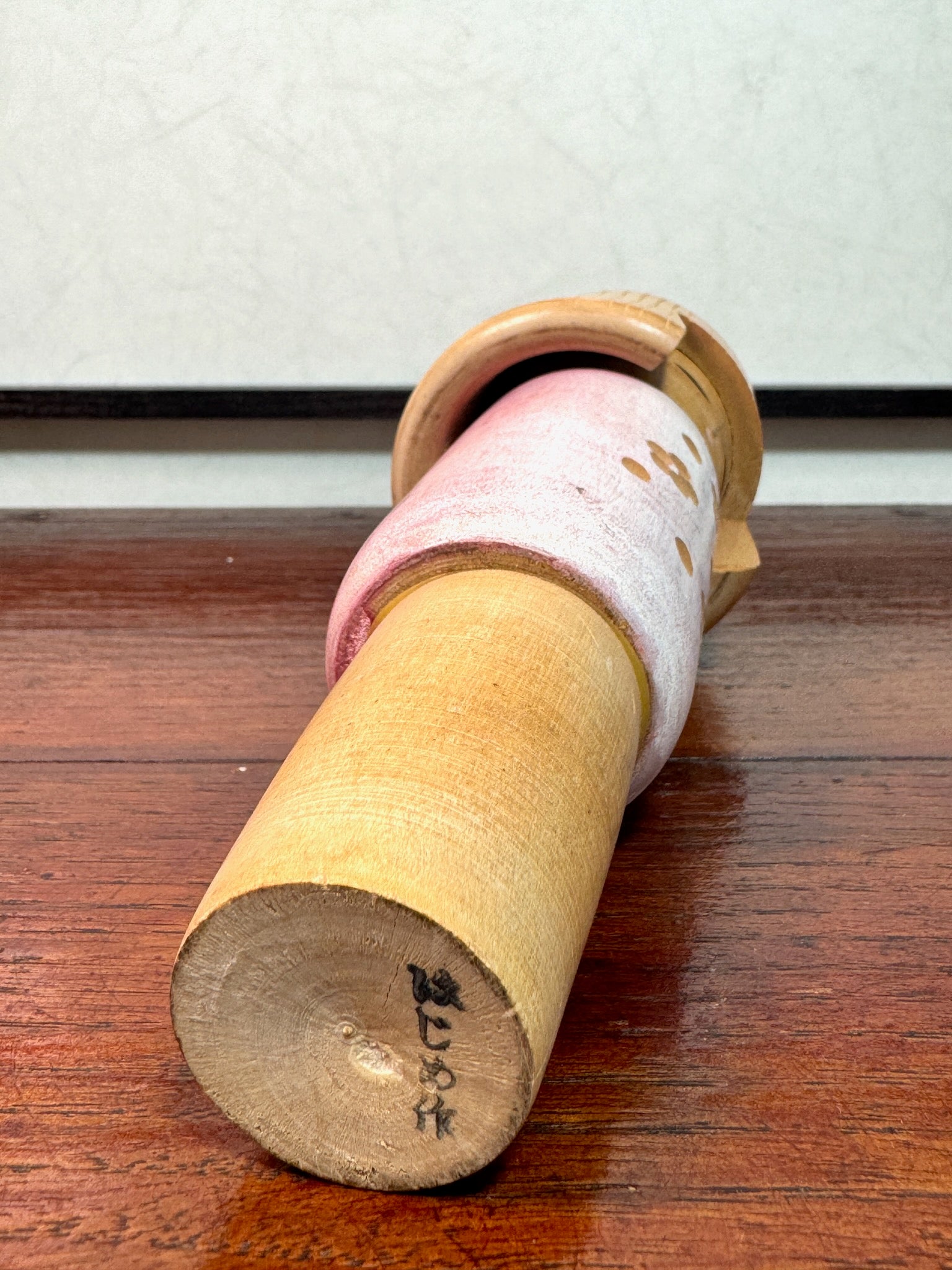 kokeshi poupée japonaise en bois de Miyashita Hajime, corps blanc et rose avec fleurs de prunier gravées, signature de l'artisan