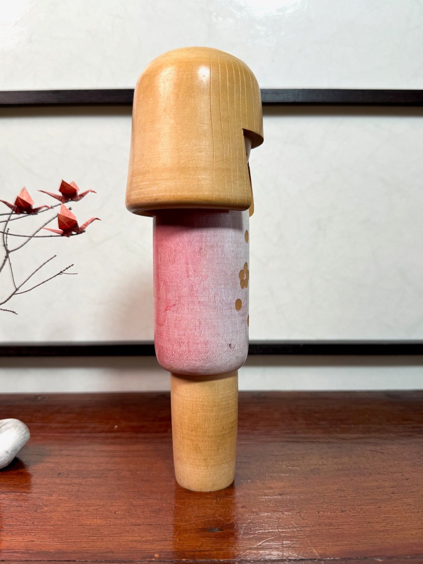 kokeshi poupée japonaise en bois de Miyashita Hajime, corps blanc et rose avec fleurs de prunier gravées, profil droit