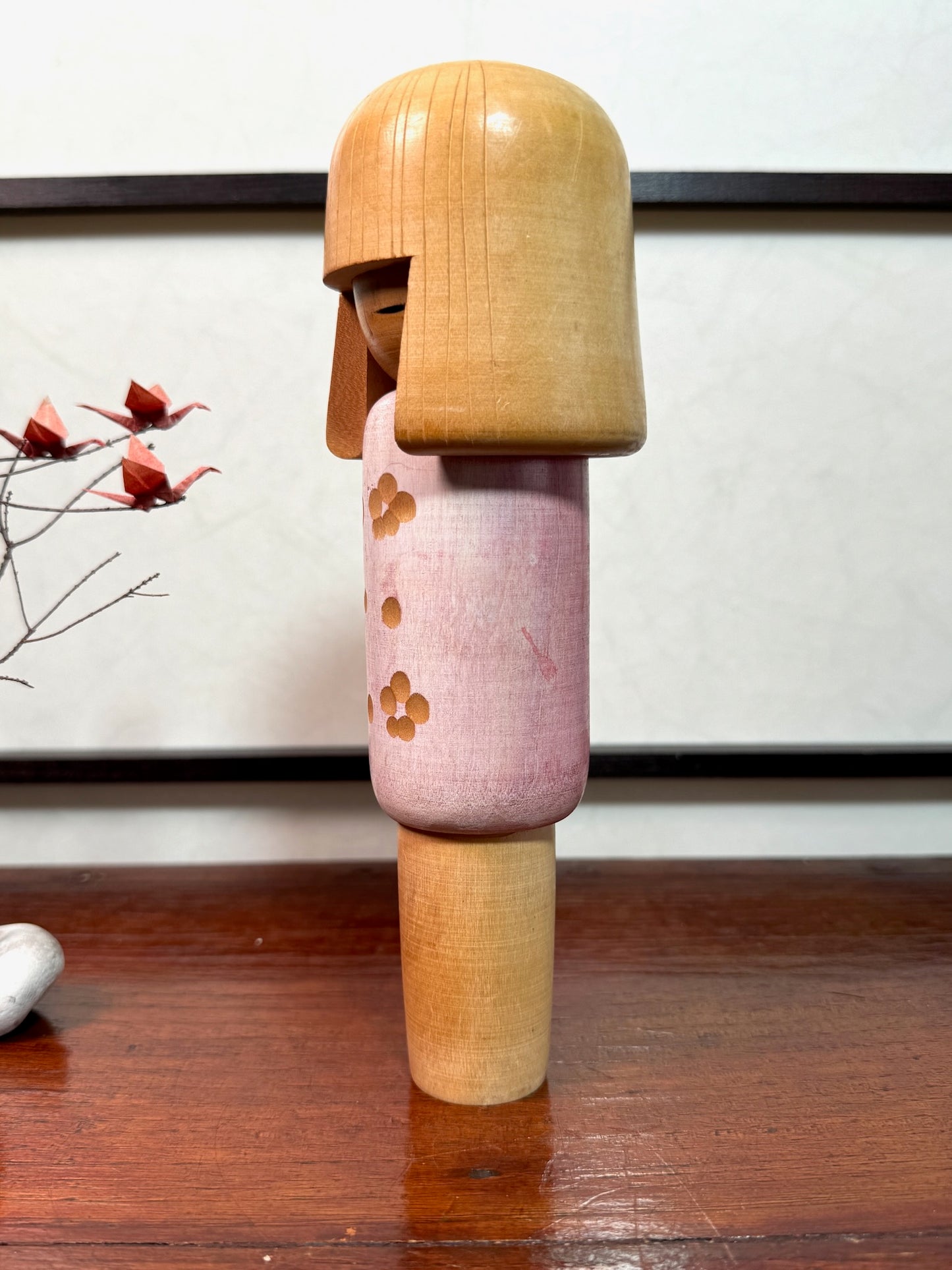 kokeshi poupée japonaise en bois de Miyashita Hajime, corps blanc et rose avec fleurs de prunier gravées, profil gauche