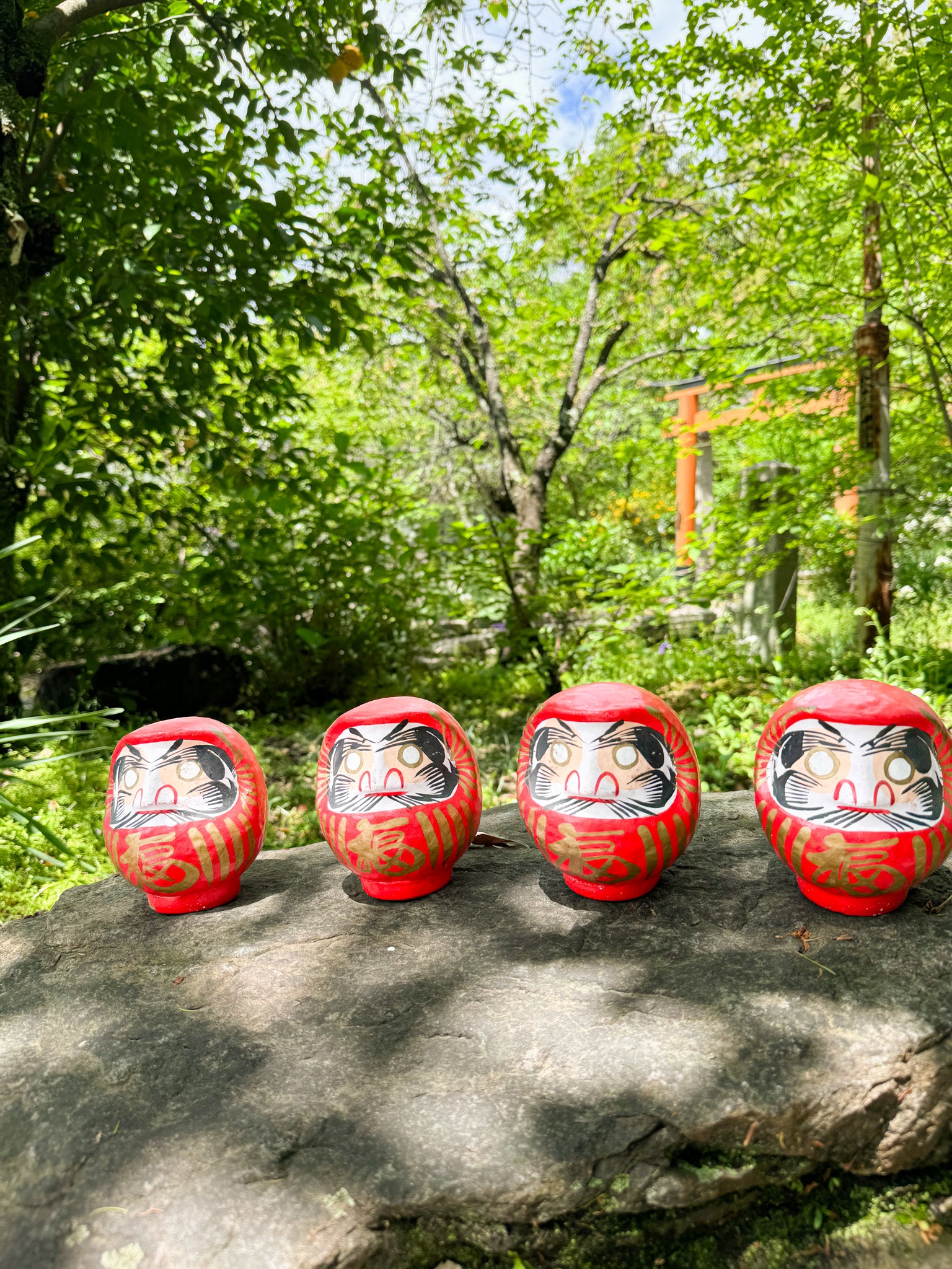 Daruma papier mache sur pierre