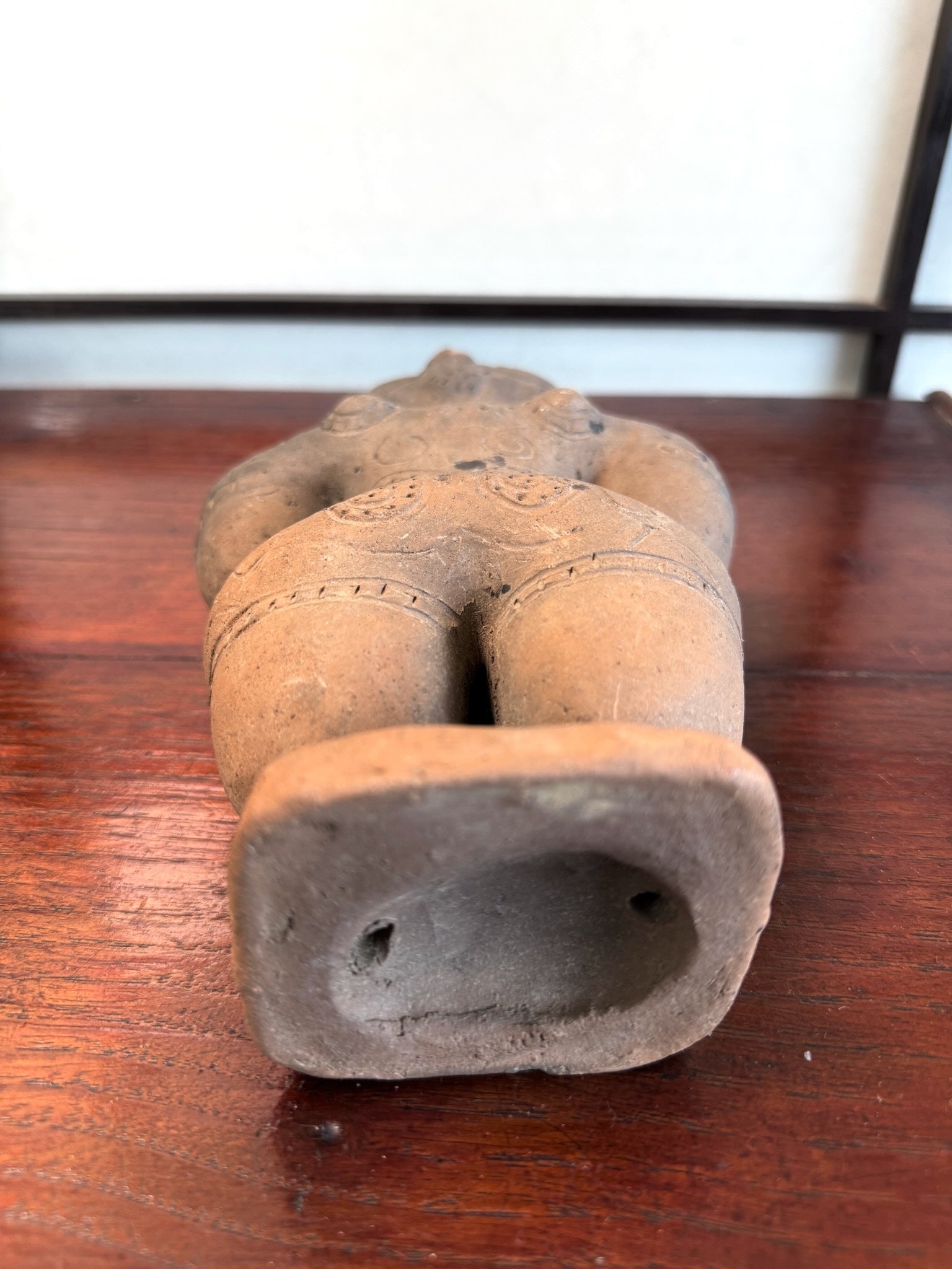 Réplique de statuette japonaise en argile de la période Jomon avec des motifs gravés sur le dos., le dessous