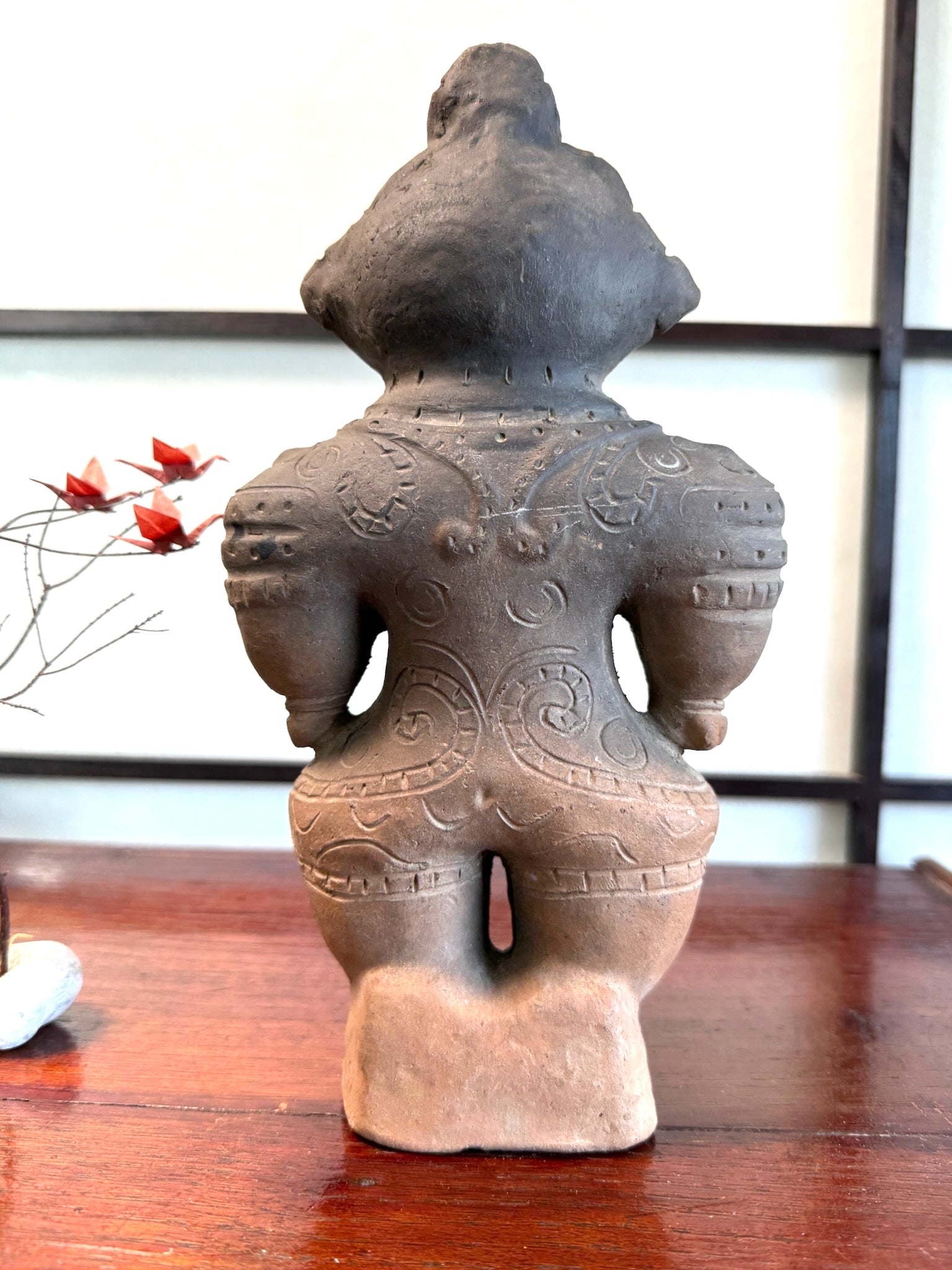 Réplique de statuette japonaise en argile de la période Jomon avec des motifs gravés sur le dos, vu de dos