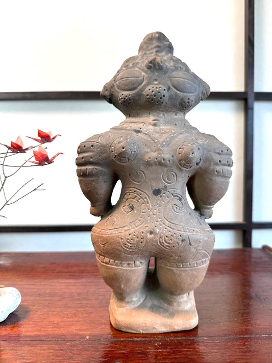 Réplique de statuette japonaise en argile de la période Jomon avec des motifs gravés sur le dos.