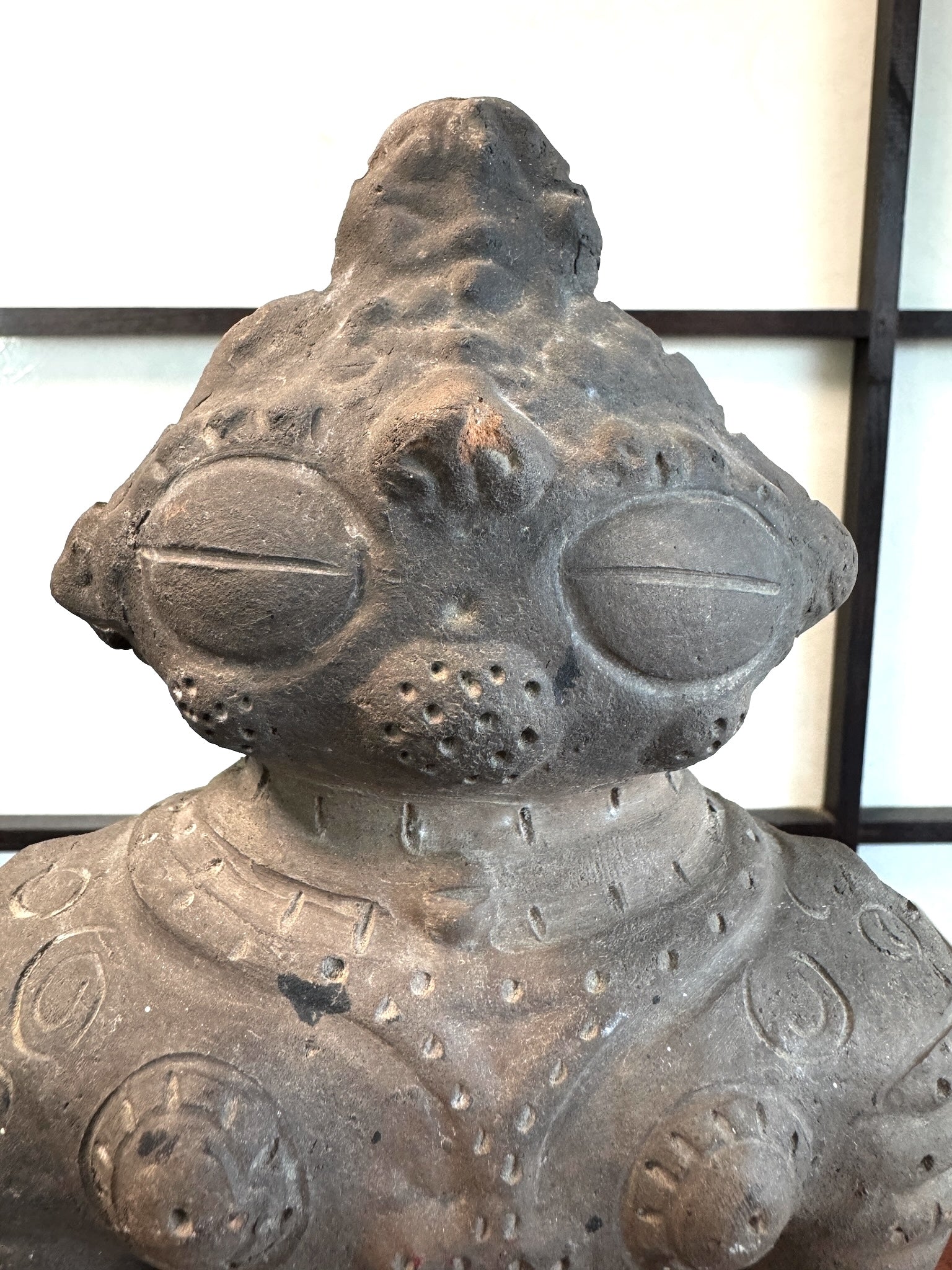 Réplique de statuette japonaise en argile de la période Jomon avec des motifs gravés sur le dos., gros plan visage