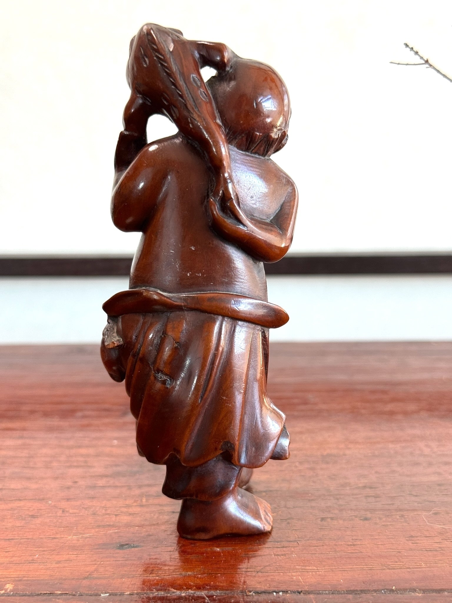 dieu du bonheur japonais Ebisu en bois, vu de dos