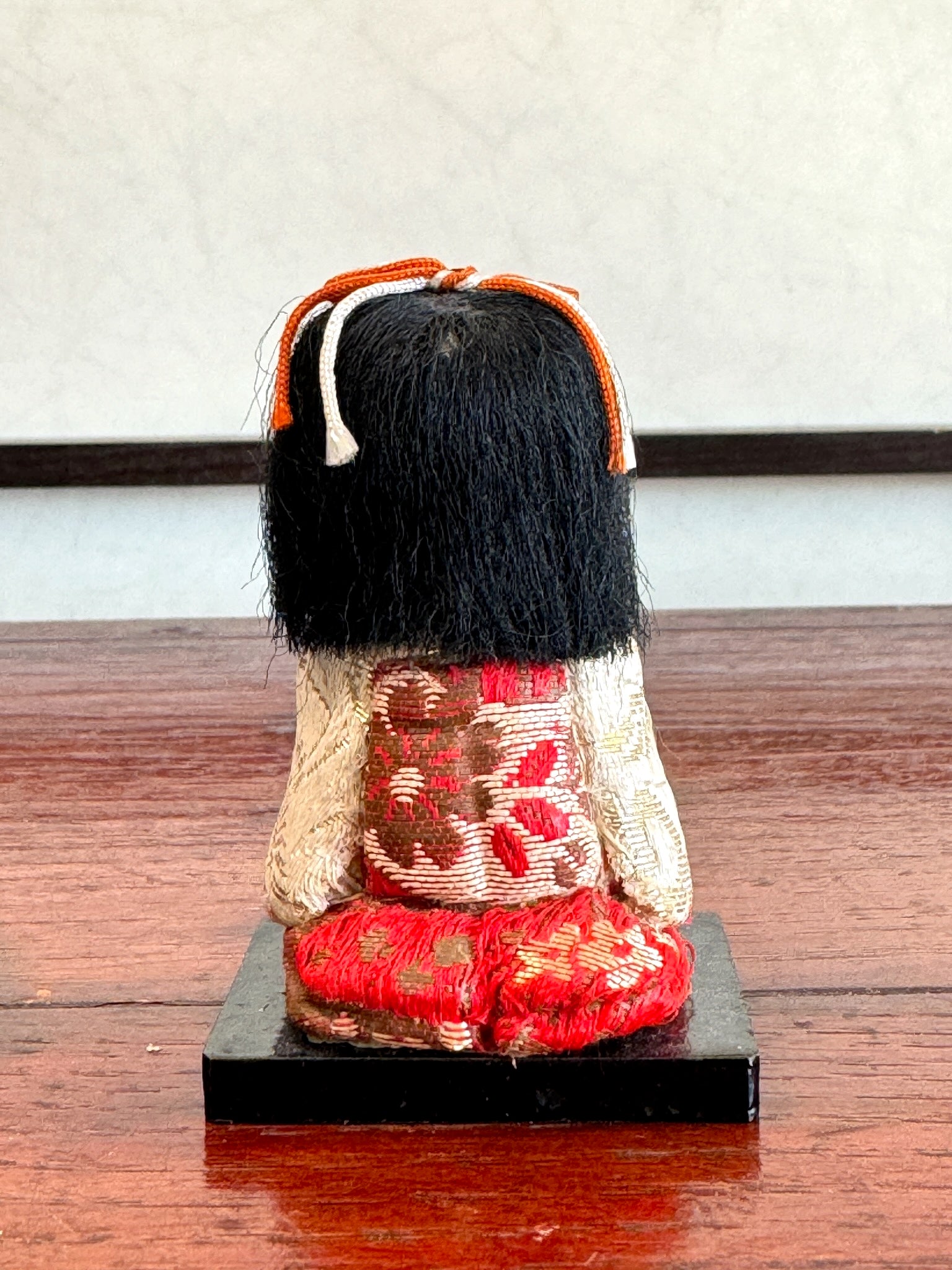 poupée japonaise kimekomi miniature avec plateau repas en laque noire, vu de dos