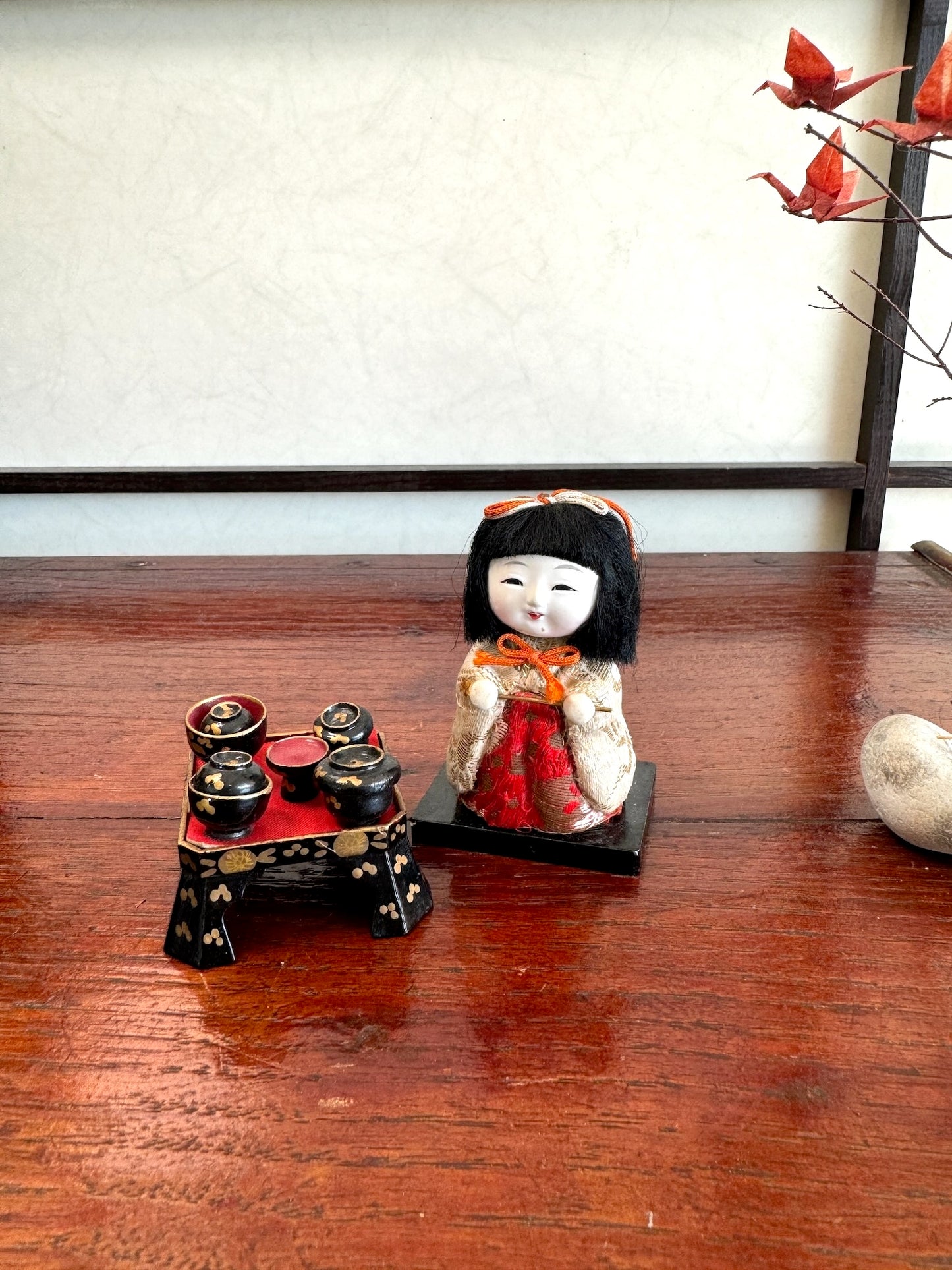 poupée japonaise kimekomi miniature avec plateau repas en laque noire, vu de 3/4