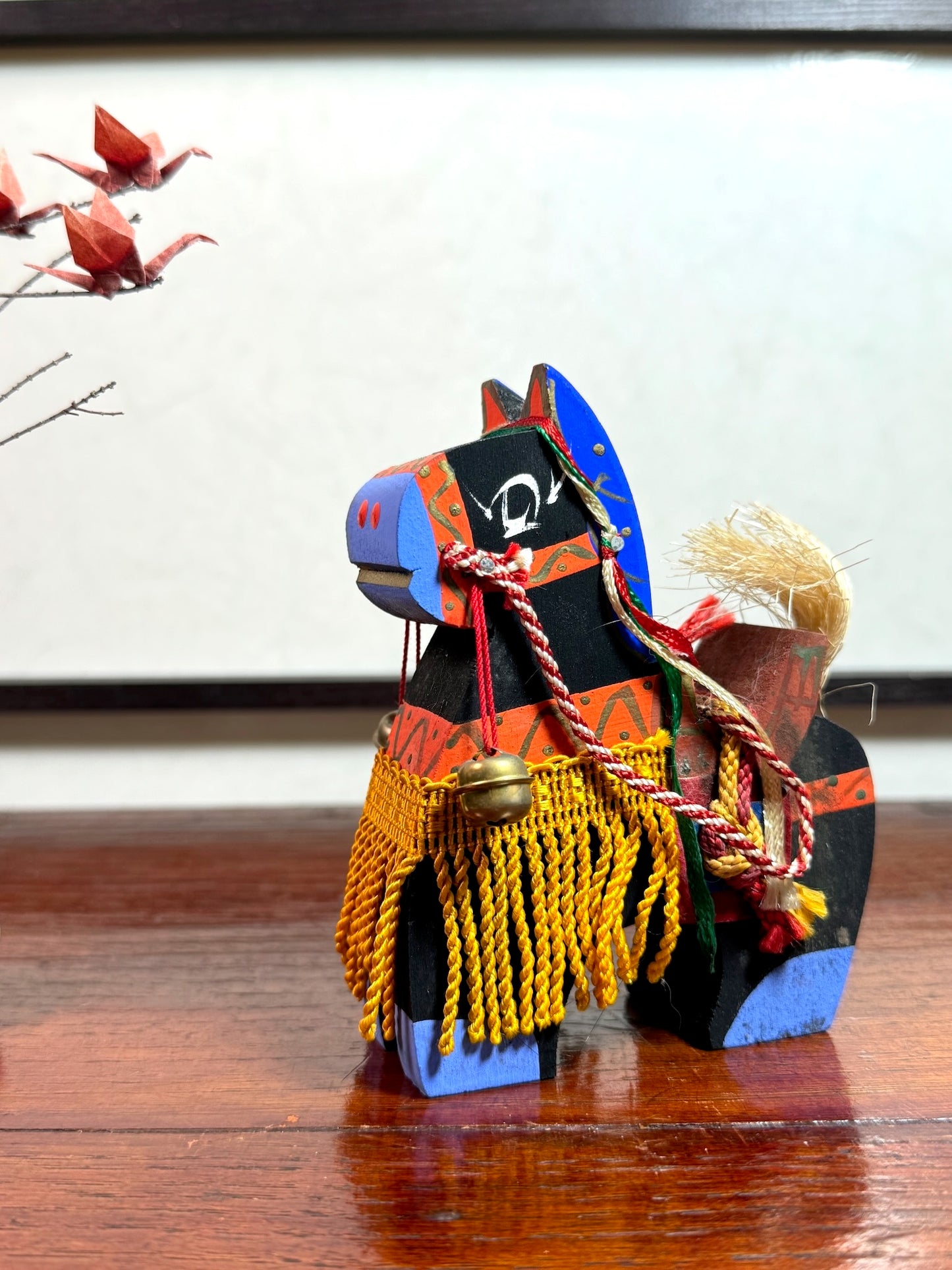 cheval japonais en bois chagu chagu, noir avec décorations de couleurs vives et clochettes, profil gauche