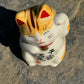 chat japonais Maneki Neko en céramique blanc et jaune, vu de dessus