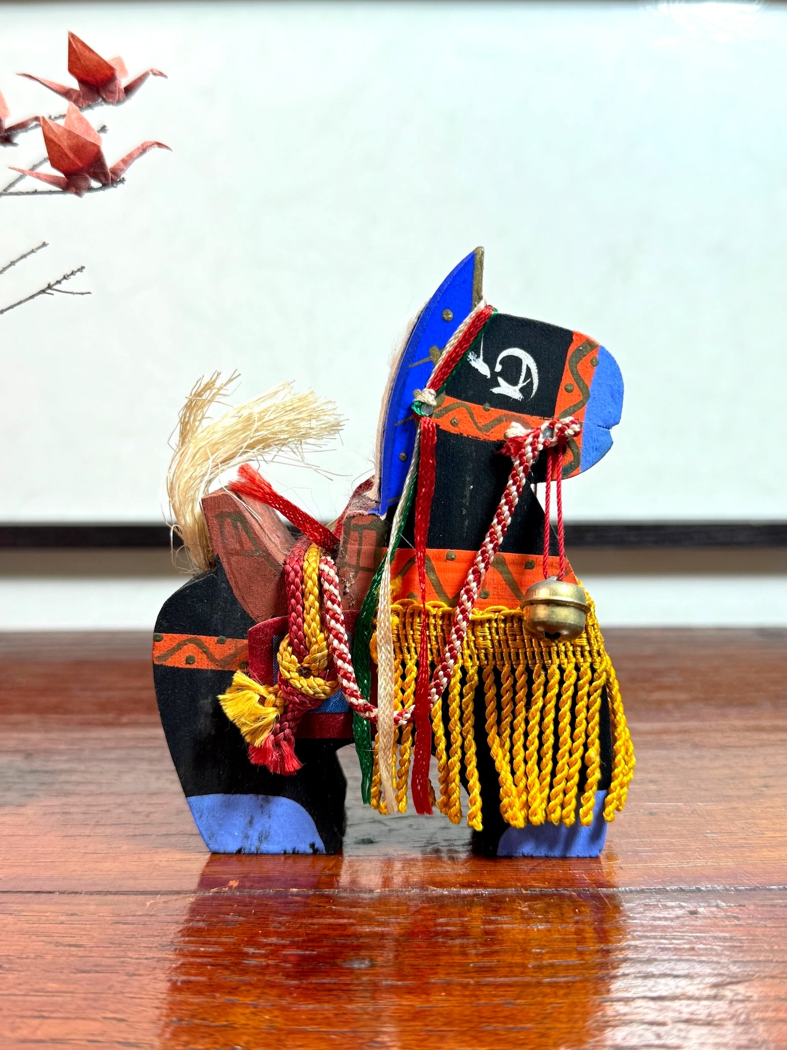 cheval japonais en bois chagu chagu, noir avec décorations de couleurs vives et clochettes, profil droit