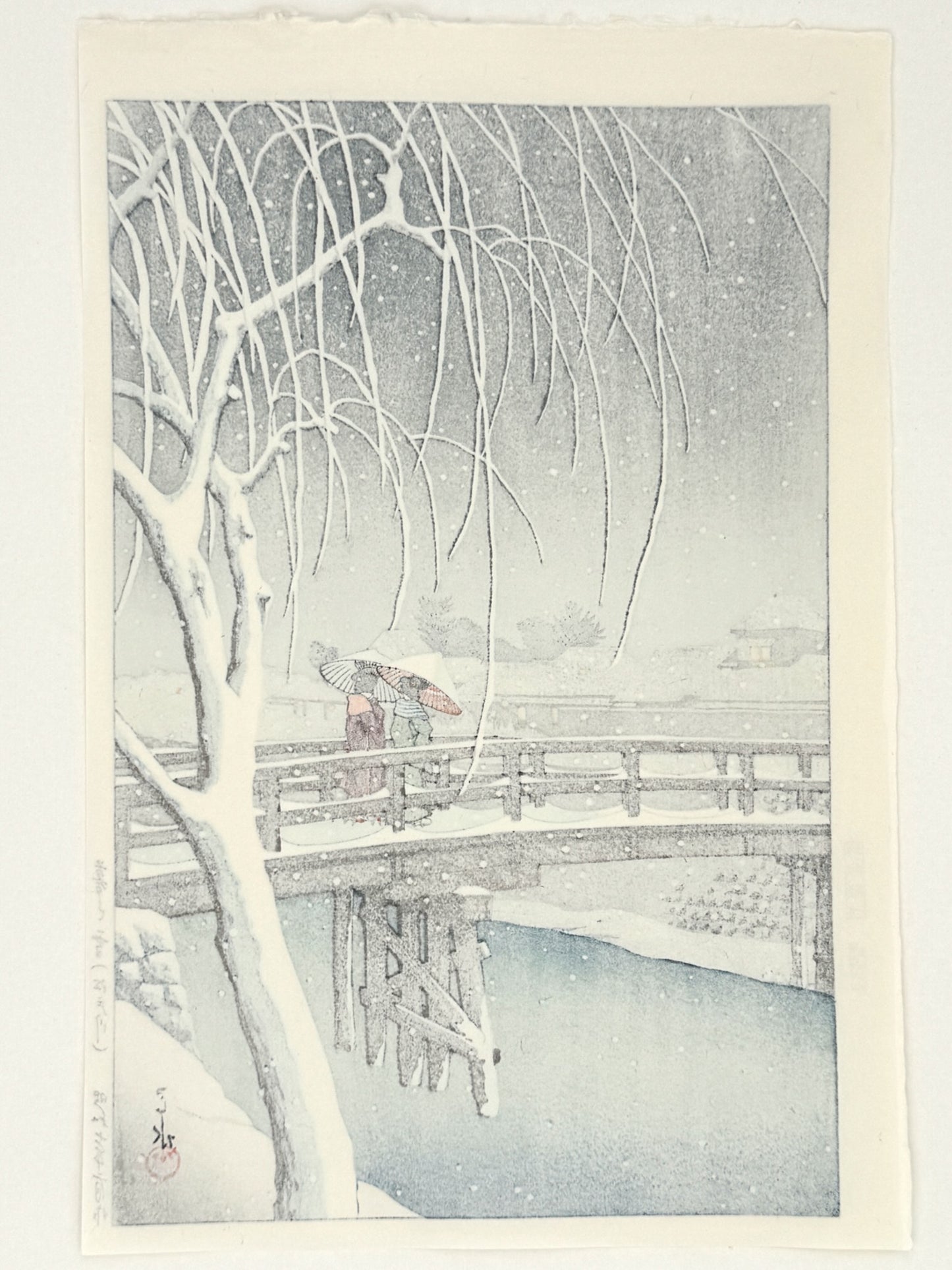 estampe japonaise de Kawase Hasui, deux femmes avec parapluies traverse un pont sous une tempête de neige, dos de l'estampe