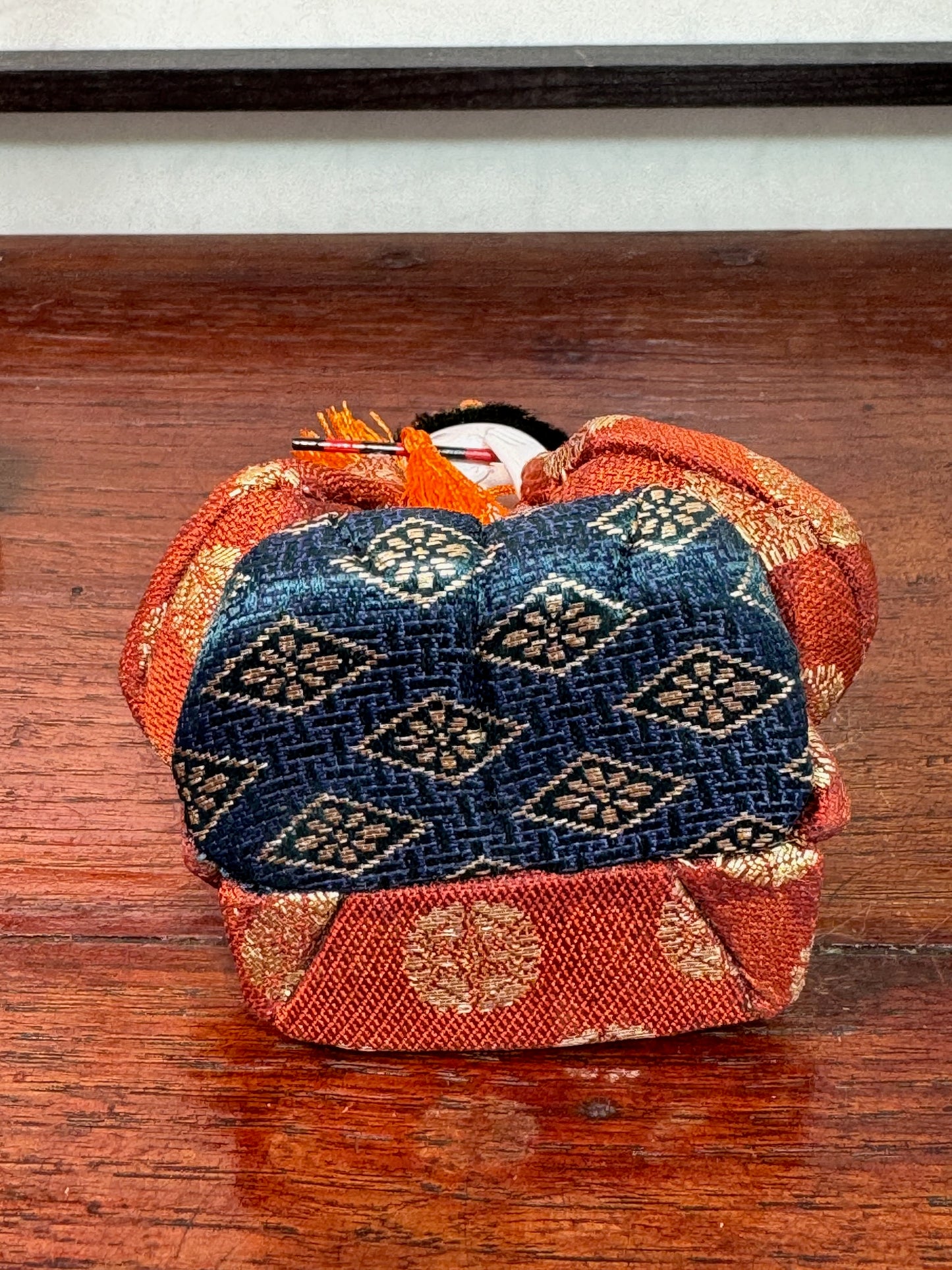 poupée japonaise gosho avec une flûte traversière dans les mains, en kimono orange. musicien pour le Hina Matsuri, dessous