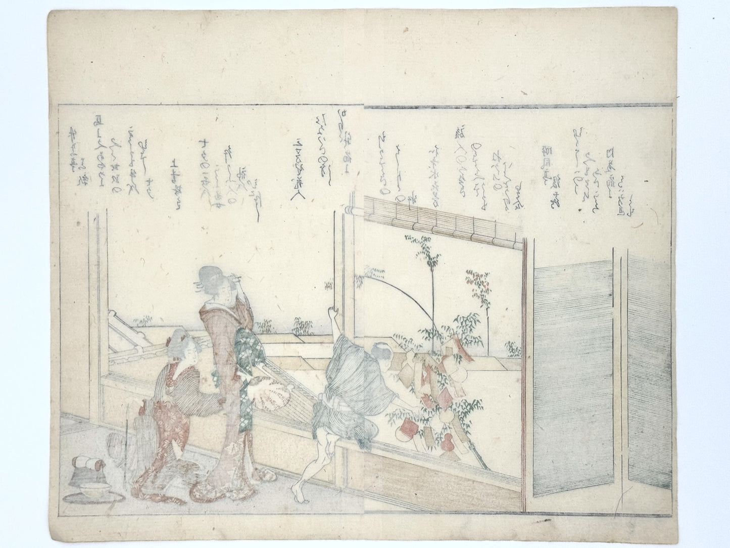 estampe japonaise de Hokusai, deux femmes en kimono et un homme accrochent de papiers de voeux sur un bambou pour Tanabata. Poème Kyoka en japonais sur la partie haute de l'estampe, verso de l'estampe