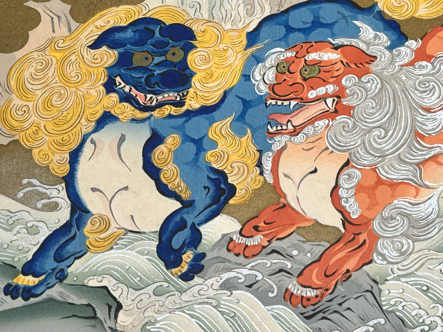 estampe japonaise école Kano, deux lions Shishi, sautant au dessus d'une cascade, gros plan, l'un bleu à la crinière or et l'autre lion orange à la crinière argent