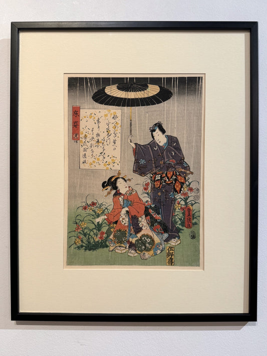 estampe japonaise de Kunisada, un homme debout sous la pluie protège avec son parapluie une femme accroupie qui cueille des fleurs, avec un cadre fin noir