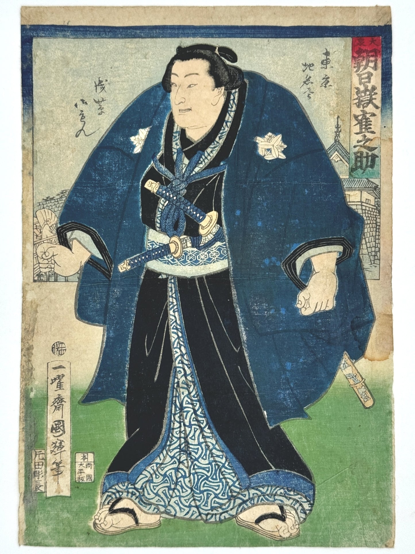 Estampe Japonaise de Kuniteru Utagawa, sumo en habit de ville. Kimono bleu et noir. Sabres à la taille. Paysage derrière lui, quartier de Tokyo, Oizumi. Visage souriant. 