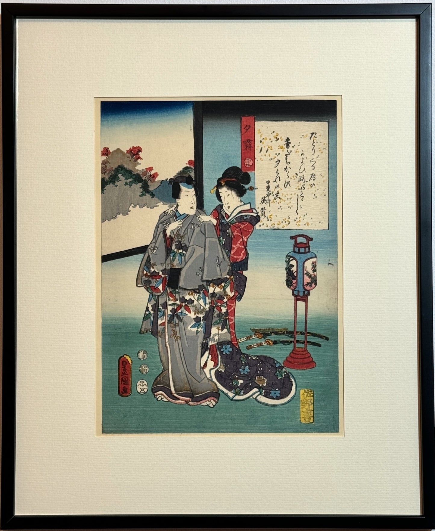 Estampe Japonaise encadrée de Kunisada une geisha en kimono rouge habille un homme d'un kimono gris, sabres au sol, lanternes sur pied, cadre noir