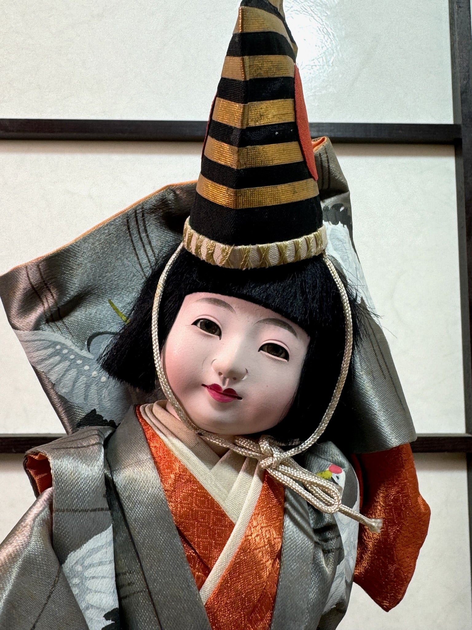 poupée japonaise ancienne danseur en kimono gris argent motif grue, gos plan sur le visage doux et souriant