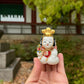 Poupée japonaise traditionnelle gosho, petit garçon potelé, tient éventail dans sa main et chapeau doré sur sa tête.