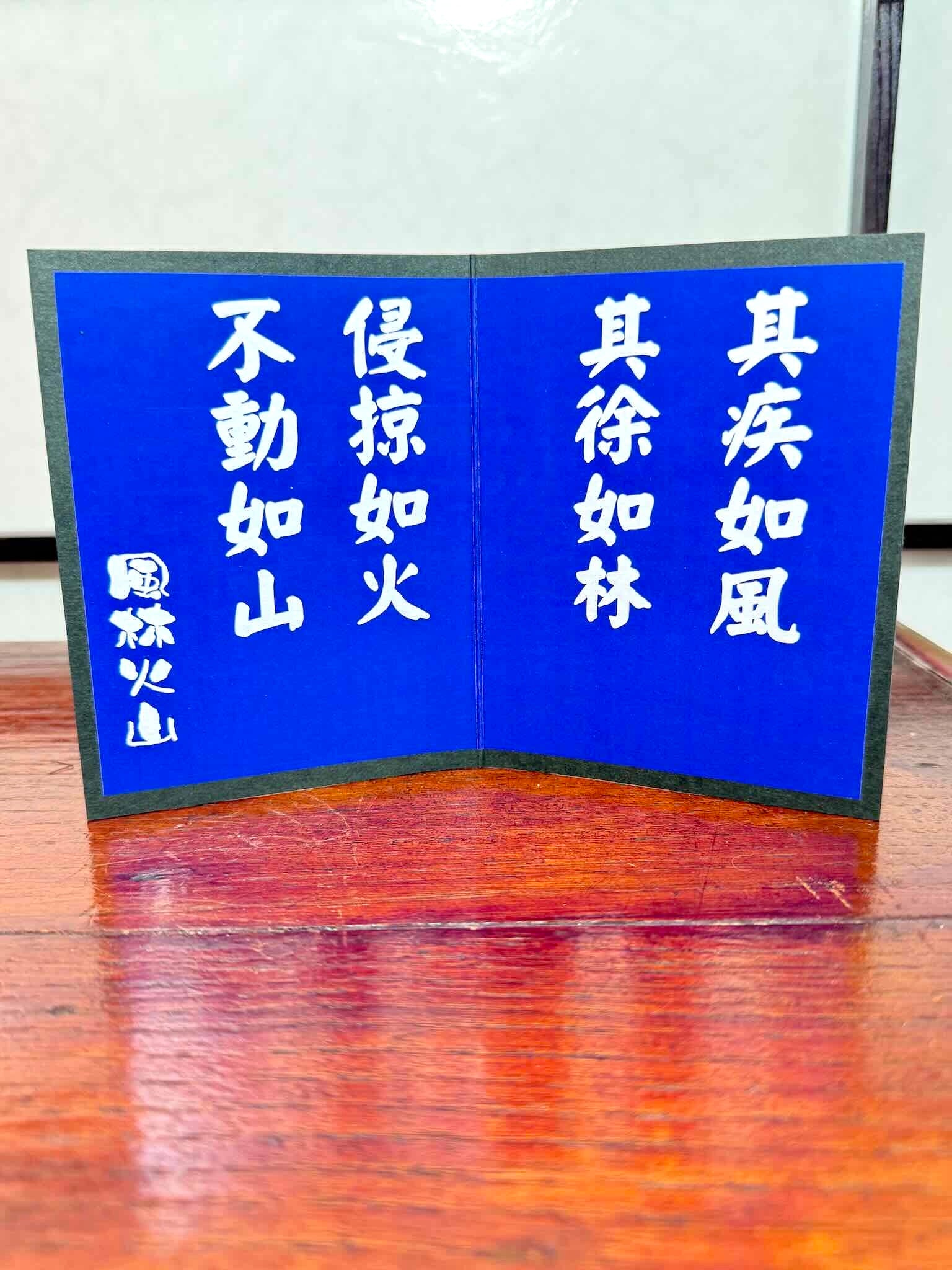 samouraï en céramique avec paravent bleu calligraphié, paravent avec inscription en japonais code de la guerre